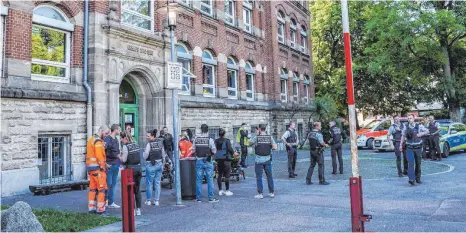  ?? FOTO: KOHLS/DPA ?? Polizisten im Einsatz vor einer Schule in Esslingen: Nach Angaben der Polizei sind dort bei einer Gewalttat eine Frau und ein Kind verletzt worden.