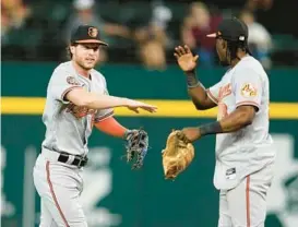  ?? TONY GUTIERREZ/AP ?? Orioles outfielder Brett Phillips, left, and shortstop Jorge Mateo celebrate their 6-3 win over the Rangers in Arlington, Texas, on Wednesday.