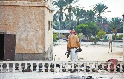  ?? AHMED HASSAN/EFE ?? Un hombre recoge pertenenci­as de las víctimas del asalto al templo sufí.