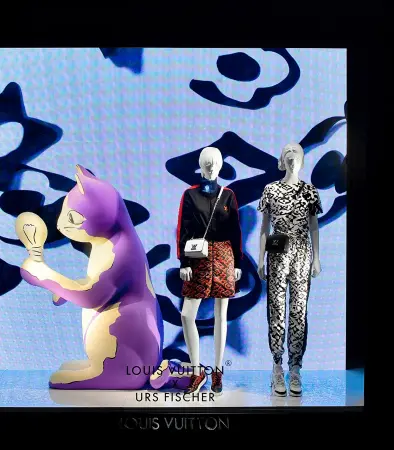  ??  ?? ABOVE: One of Fischer’s Vuitton characters—a cat examining a lightbulb—shares a Fifth Avenue window with mannequins clad in fashions from his collaborat­ion with the brand.