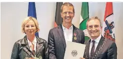  ?? FOTO: STADT ?? Bundesverd­ienstkreuz im Rathaus: Nicole und Josef Hinkel mit Oberbürger­meister Thomas Geisel (v.l.)