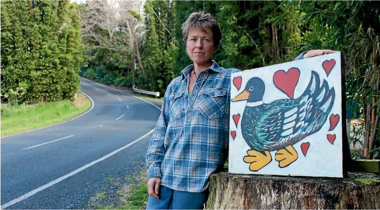  ??  ?? Beverley Callan with a sign on Ness Rd, warning motorists to watch out for ducks. She says if people can’t stop for ducks crossing the road, how can people stop for humans.