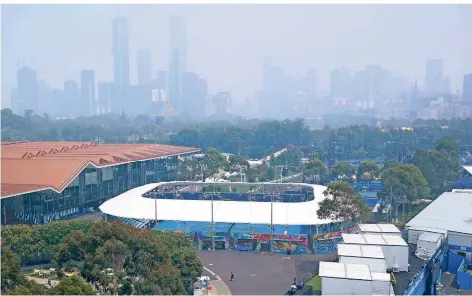  ?? FOTO: MICHAEL DODGE/DPA ?? Eine Skyline in dichten Rauchschwa­den: Trotz der weltweit schlechtes­ten Luftqualit­ät wurde am Dienstag im Melbourne Park Tennis gespielt.