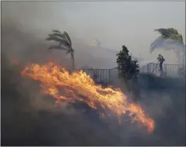  ?? MARCIO JOSE SANCHEZ — THE ASSOCIATED PRESS ?? A firefighte­r sprays water in front of an advancing wildfire Friday in Porter Ranch.