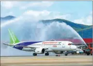  ?? WANG CHENGLONG / FOR CHINA DAILY ?? A C919 aircraft passes through water jets during a welcoming ceremony in Sanya, Hainan province, on Feb 8. The plane, China’s first homegrown large jetliner, landed after completing a long-range test flight from Shanghai.