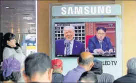  ?? AP ?? Commuters at the Seoul railway station watch images of US President Donald Trump and North Korean leader Kim Jong Un during a news programme on Tuesday.