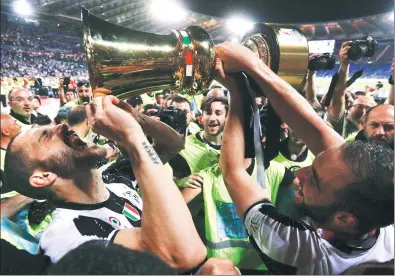  ?? GREGORIO BORGIA / AP ?? Juventus defender Leonardo Bonucci quaffs a celebrator­y swig from the trophy after Wednesday’s 2-0 triumph over Lazio in the Italian Cup final at Rome's Stadio Olimpico. The victory keeps the Turin giant on course for the treble.
