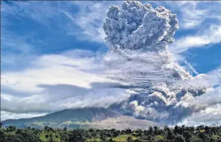  ?? AFP ?? Indonesia’s Mount Sinabung erupted on Monday, sending a massive column of ash and smoke 5km into the air. Local communitie­s n were soon blanketed by a thick layer of debris. No deaths or injuries have been reported so far. Activity in the volcano on Sumatra island had picked up in recent days, including a pair of smaller eruptions over the weekend.
Bloomberg