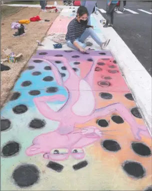  ?? The Sentinel-Record/Richard Rasmussen ?? CLASSIC ‘TOONS:
Hot Springs World Class High School art student Anna Moreno works on a Chalk Walk project featuring the “Pink Panther” that she created with Raina Holstine, not pictured, Monday at Hot Springs High School, above; art student Mariah Turner works on her “Mickey Mouse” creation, below.