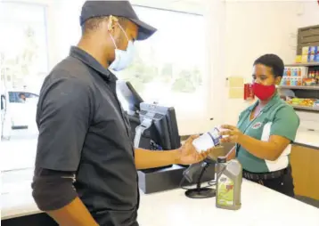  ??  ?? A customer being served at the RUBIS convenienc­e store at the Old Harbour Road station.