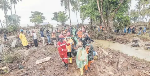  ?? — Reuters photo ?? Rescue workers carry a body bag containing the remains of a victim of a tsunami at Sumur district in Pandeglang, Banten province, Indonesia in this photo taken by Antara Foto.