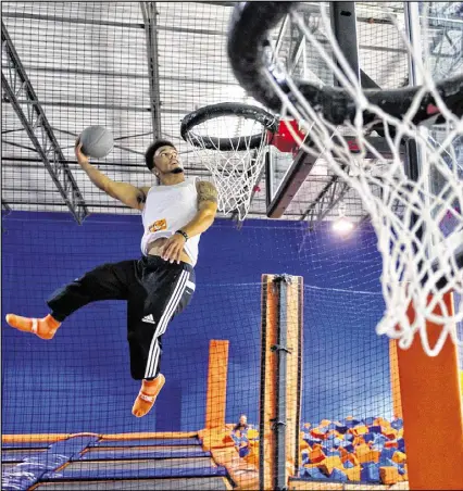  ?? CONTRIBUTE­D BY JONATHAN PHILLIPS / 2014 ?? Malcolm Reid bounces into the air as he slams a basketball through the hoop at Sky Zone indoor trampoline park in Suwanee.