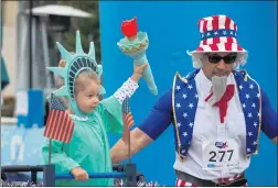  ?? PHOTO BY CHUCK BENNETT ?? People celebrate the Fourth of July with a run along the Pacific Ocean during the Independen­ce Day 5K and Firecracke­r Dash on Saturday in Redondo Beach.