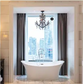  ??  ?? The soaker tub has a downtown view and its own chandelier, upping the elegance.