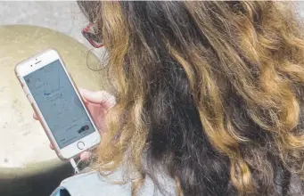  ?? Mary Altaffer, Associated Press file ?? A woman uses a ride-hailing app while waiting for a ride outside Grand Central Terminal in New York in August last year.