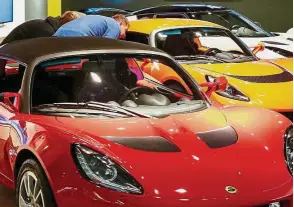  ??  ?? Technology-driven: Visitors looking at Lotus cars in a showroom in Kiev, Ukraine. Proton-owned Lotus may also generate synergies. – Reuters