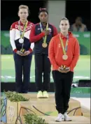  ?? JULIO CORTEZ — THE ASSOCIATED PRESS FILE ?? In this Aug. 14, 2016 file photo, United States’ gold medal winner Simone Biles, center, stands for her national anthem during the e 2016 Summer Olympics.
