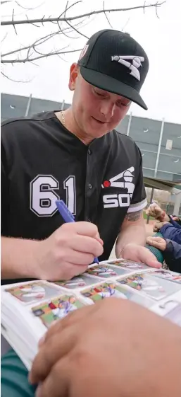  ?? MORRY GASH/AP ?? Reliever Ryan Burr signs autographs Wednesday in Glendale, Ariz.