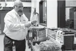  ?? Photos by Marvin Pfeiffer / San Antonio Express-News ?? Mickey Argo shows lithium-ion batteries used by Tesla Model X (lower center) and Chevrolet Volt (right) in the testing facility at Southwest Research Institute.