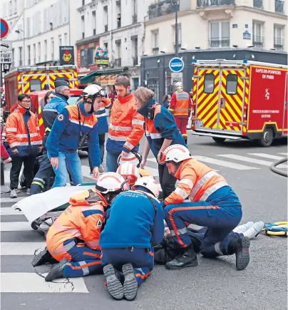  ??  ?? RESPONSE: Firefighte­rs tend to a wounded person near the site of the gas leak explosion in central Paris