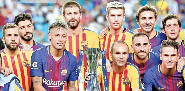  ?? PIC/AP/PTI ?? Barcelona players pose with the trophy after defeating Real Madrid in an Internatio­nal Champions Cup football match