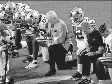  ?? [ASSOCIATED PRESS FILE PHOTOS] ?? The Dallas Cowboys, led by owner Jerry Jones, center, take a knee prior to the national anthem and an NFL game against the Arizona Cardinals on Sept. 25 in Glendale, Ariz. Jones stated that players who disrespect the flag would not play for his team...