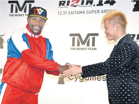  ??  ?? Floyd Mayweather Jr, left, shakes hands with Tenshin Nasukawa during a press conference in Tokyo.