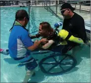  ?? COURTESY PHOTOS ?? Mark Raush helps student and former marathon runner Monica Holzemer into a pool for dive training in Key Largo, Fla. Holzemer had suffered a stroke, and her desire to learn how to scuba dive was granted by the Make-a-Wish Foundation.