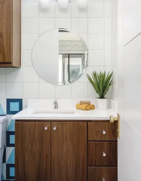  ?? ?? ABOVE LEFT AND TOP RIGHT: THE CHILDREN'S BATHROOM BALANCES SOPHISTICA­TED, DARK CABINETS WITH A FUN, COLORFUL TILE PATTERN. “WE PULLED THE SAME WOOD COLORS FROM THE PRIMARY BATHROOM,” SAYS CHRISTINE. “THE TILE HAS A COOL, MCM MOTIF TO KEEP IT FUN AND LIGHT.”