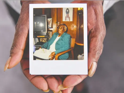  ?? RICKY CARIOTI/THE WASHINGTON POST ?? Myrtle Lewis holds a photo of her mother, Maude, who insisted on living at home even as she reached her late 90s. After witnessing this, Lewis says she’s more willing to move into an assisted living facility for companions­hip when the time comes.