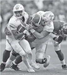  ??  ?? Alabama defensive lineman Joshua Frazier, center, tackles Tennessee quarterbac­k Jarrett Guarantano, left, during the first half.