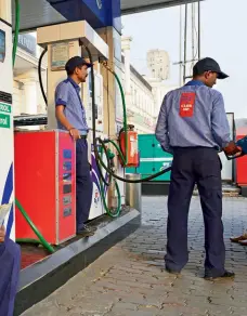  ??  ?? RAKING IT IN A fuel station in New Delhi