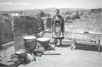  ??  ?? A volunteer at the Sincedeni Elderly Centre prepares meals with food rescued by Chefs with Compassion in Eldorado Park, Johannesbu­rg.