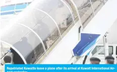  ??  ?? Repatriate­d Kuwaitis leave a plane after its arrival at Kuwait Internatio­nal Airport yesterday.