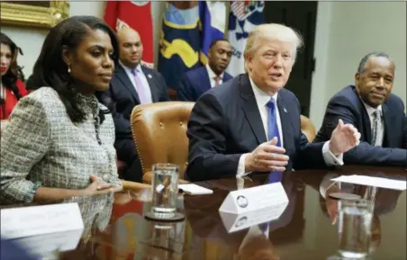  ?? EVAN VUCCI — THE ASSOCIATED PRESS FILE ?? President Donald Trump, center, is flanked by White House staffer Omarosa Manigault Newman, left, and then-Housing and Urban Developmen­t Secretary-designate Ben Carson as he speaks during a meeting on African American History Month in the Roosevelt Room of the White House in Washington. Manigault Newman, who was fired in December, released a new book “Unhinged,” about her time in the White House.