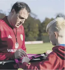  ??  ?? 0 Malky Mackay signs a shirt for a fan at training yesterday.