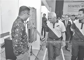  ??  ?? MELAWAT: Yusof (tengah) melawat gerai pameran johan SCINTEX kategori Institut iaitu ILP Kota Kinabalu.