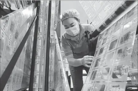  ?? GENG YUHE / FOR CHINA DAILY ?? An employee checks equipment at a plastic package production facility in Lianyungan­g, Jiangsu province, in August.