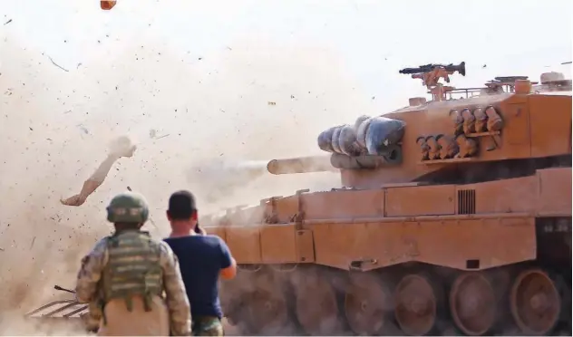  ?? Agence France-presse ?? ↑
Turkish soldiers at a position east of Ras Al Ain watch as a tank fires on positions held by fighters from the Syrian Democratic Army on Monday.