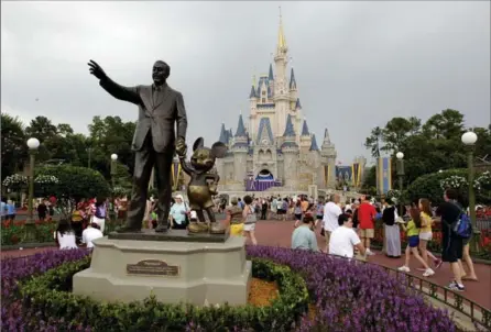  ?? JOHN RAOUX, THE ASSOCIATED PRESS ?? Visitors stroll along Main Street at Walt Disney World, in Lake Buena Vista, Fla. Ever since Walt Disney announced his huge purchase of land (more than 27,000 acres) in 1965, Orlando has been going through a transforma­tion.