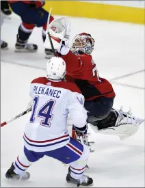  ?? Associated Press photo ?? Washington Capitals goalie Braden Holtby (70) reaches for the puck against Montreal Canadiens center Tomas Plekanec (14), of the Czech Republic, during the third period of an NHL hockey game, Saturday in Washington.