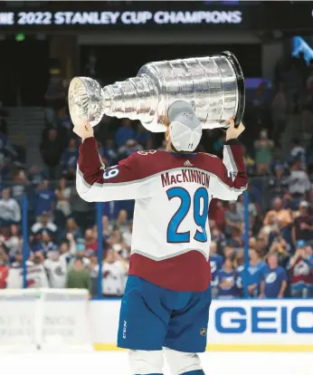  ?? CHRISTIAN PETERSEN/GETTY ?? Nathan MacKinnon hoists the Stanley Cup after the Avalanche’s title-clinching victory Sunday.