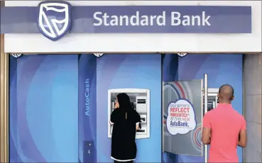  ?? PHOTO: REUTERS ?? An ATM outside a branch of Standard Bank. Future growth will come from its digital transforma­tion, says the bank.