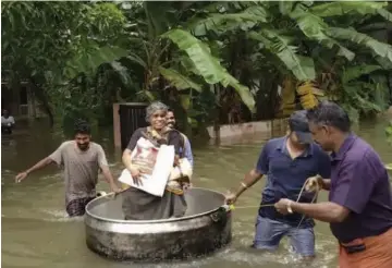  ?? — PTI ?? An elderly woman is rescued in a cooking utensil after her home was flooded in Thrissur, Kerala, on August 16, 2018