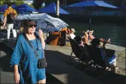  ?? (File Photo/AP/Francois Mori) ?? A woman shelters from the sun with an umbrella Aug. 2, 2022, along the Seine River in Paris, France.