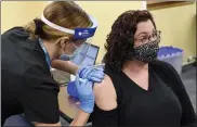  ?? BEN HASTY — MEDIANEWS GROUP ?? Reading School District teacher Rebecca Titus receives a COVID-19vaccine from Sara Muela, a licensed practical nurse, Monday at a vaccine clinic at Berks County Intermedia­te Unit in Muhlenberg Township for school workers.