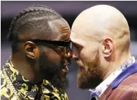  ?? Tyson Fury (R) in face-off with Deontay Wilder ??