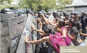  ?? EFE ?? Motín. Ayer, un grupo de familiares de presos protesta ante miembros de la Policía cerca de la Policía Estatal de Carabobo donde un motín dejó más de 70 muertos y dos policías heridos.
