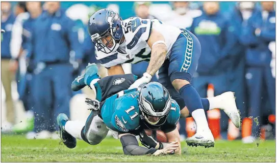  ?? [PHOTOS BY MICHAEL PEREZ/ASSOCIATED PRESS FILE PHOTO] ?? The Eagles’ Carson Wentz (11) is tackled by the Seahawks’ Mychal Kendricks, Nov. 24 In Philadelph­ia.