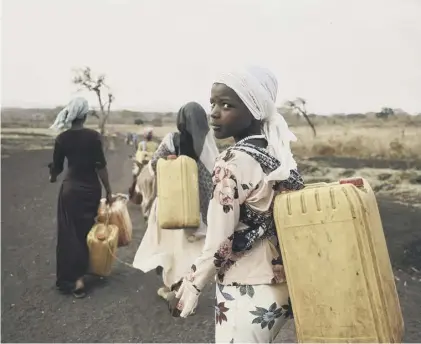  ??  ?? 0 Twelve-year-old Ansha carries water from the River Lah in Frat, Ethiopia in February last year